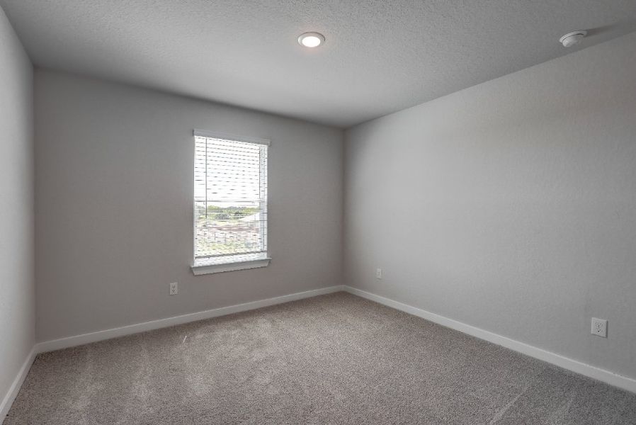 A room with a window and a carpet.