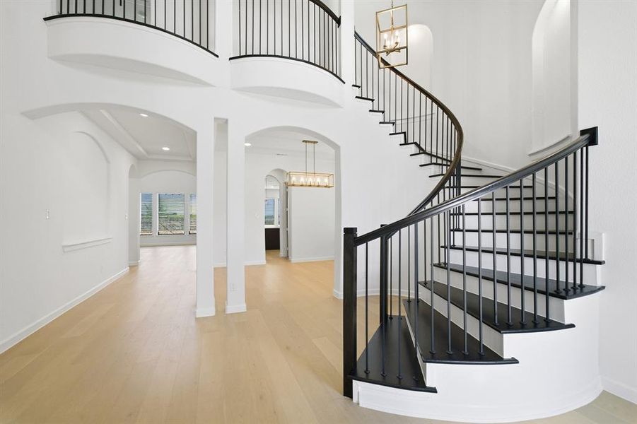 Grand spiral staircase with dark wood-finish treads and wrought iron balusters Grand spiral staircase with dark wood-finish treads and wrought iron balusters