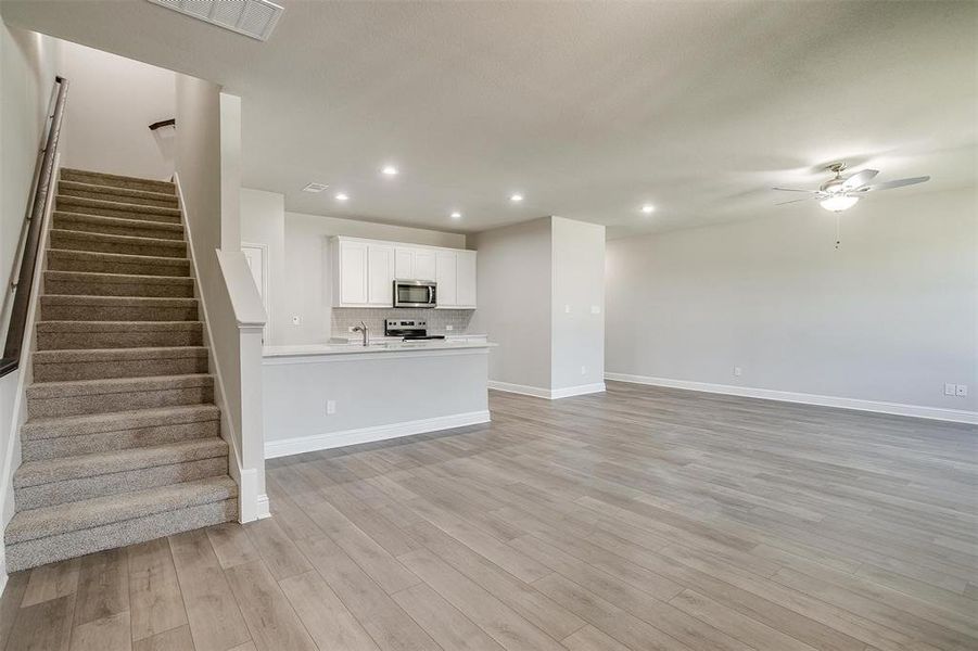 Unfurnished living room featuring recessed lighting, a ceiling fan, and light wood-style floors