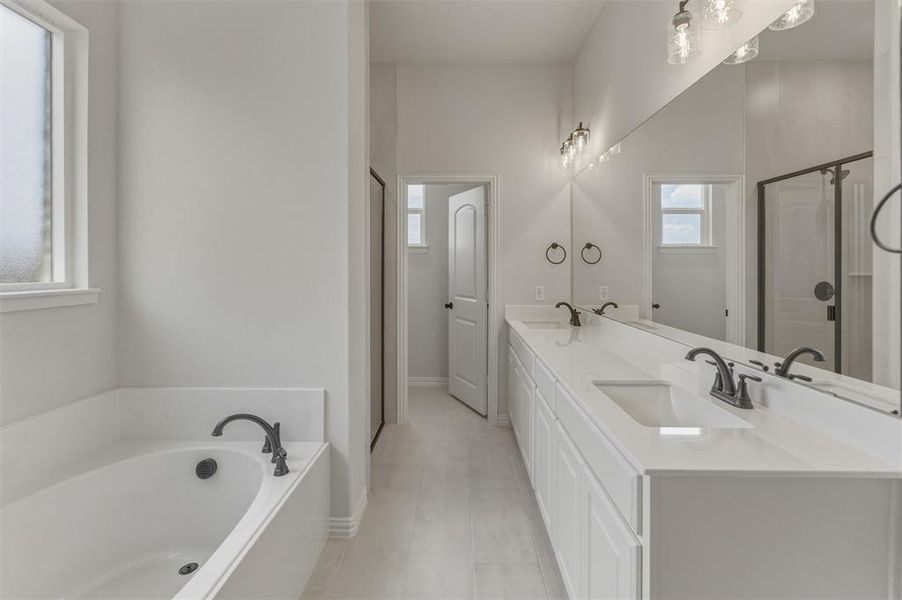 Spacious bathroom featuring a dual vanity with white countertops, undermount sinks, and matte black fixtures Spacious bathroom featuring a dual vanity with white countertops, undermount sinks, and matte black fixtures