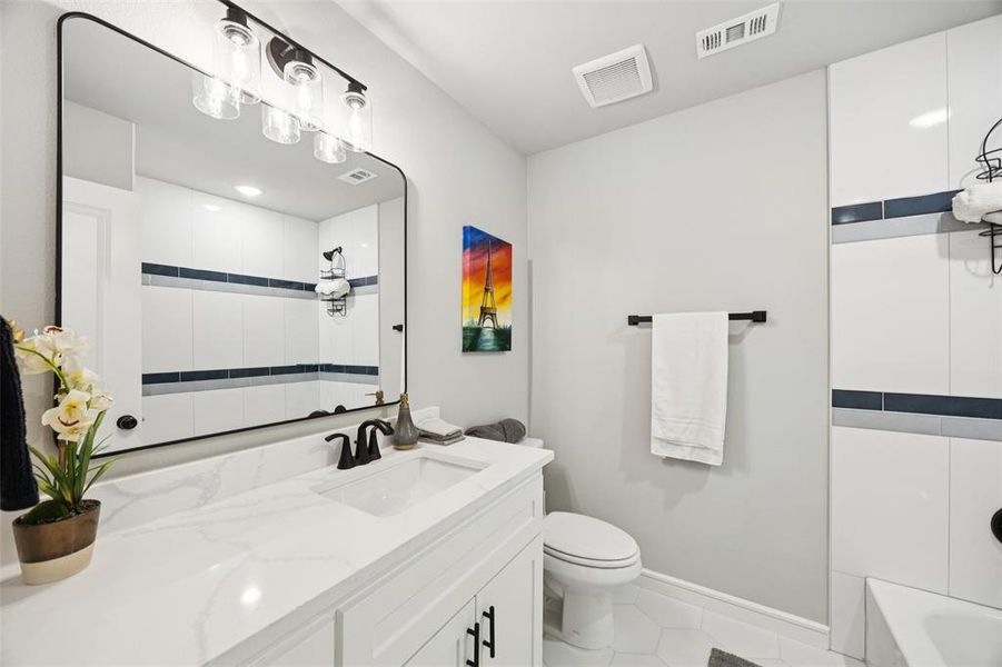 Full bath featuring vanity and light tile patterned flooring