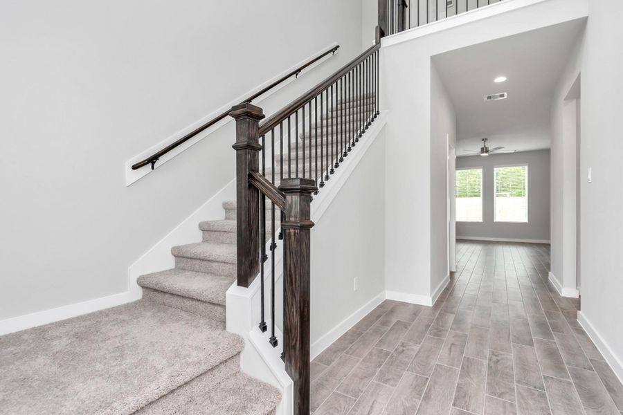 As you step into the threshold of this luxurious home, you'll soon be welcomed by an elegant glass door (to be installed). Inside, soaring ceilings amplify the spaciousness, while the refined wood-look tile flooring and oversized baseboards exude sophistication and charm. Sample photo of completed home with similar floor plan. Actual colors and selections may vary.