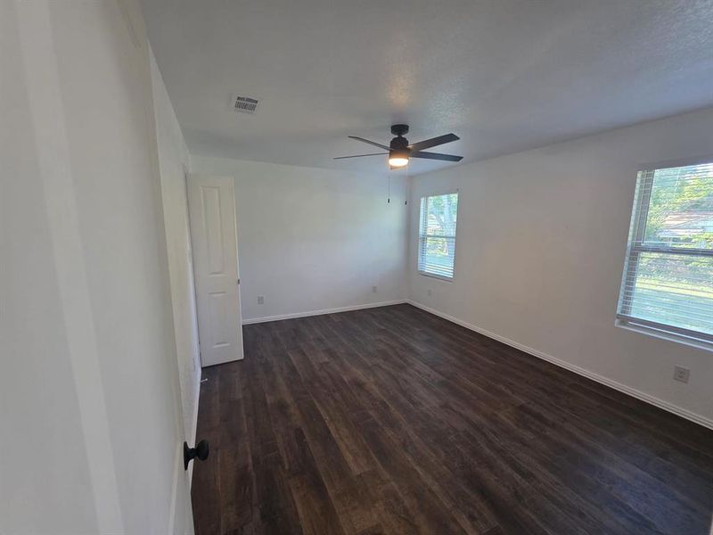 Spare room with dark wood-type flooring and a ceiling fan Spare room with dark wood-type flooring and a ceiling fan
