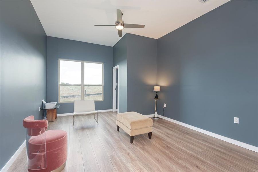 Sitting room with light wood-style floors and ceiling fan Sitting room with light wood-style floors and ceiling fan