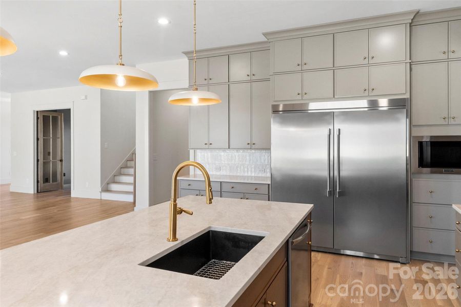 Designed to impress-abundant floor-to-ceiling cabinetry, an oversized fridge, & dramatic finishes create an elevated culinary experience.