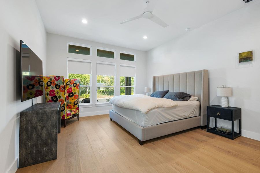 Bedroom with light wood-style flooring, ceiling fan, and recessed lighting