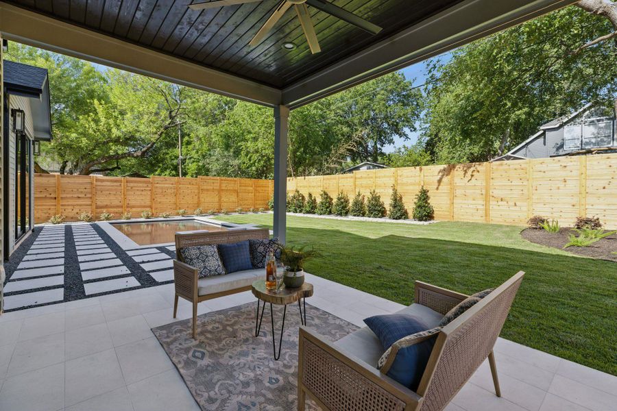 Fenced backyard with ceiling fan, a patio, and an outdoor living space
