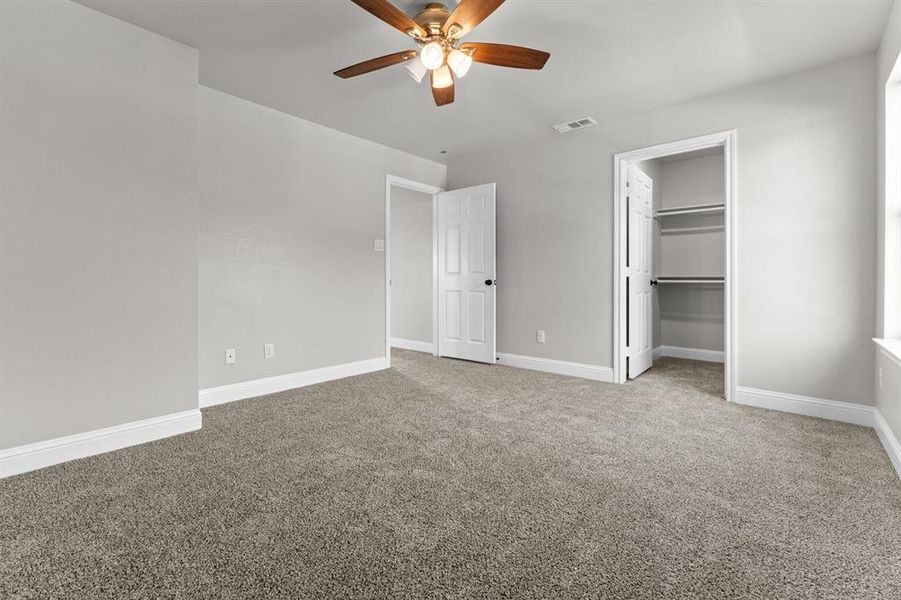 Unfurnished bedroom featuring carpet flooring, baseboards, a ceiling fan, and a closet Unfurnished bedroom featuring carpet flooring, baseboards, a ceiling fan, and a closet