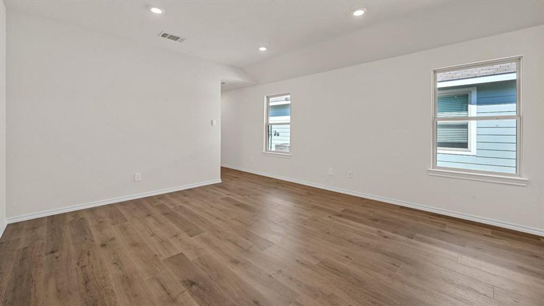 Spacious interior featuring wood-finish flooring, recessed lighting, white walls, and bright white trim