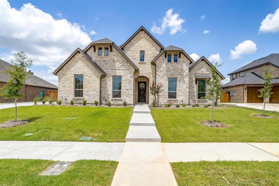 French country home with a garage and a front yard