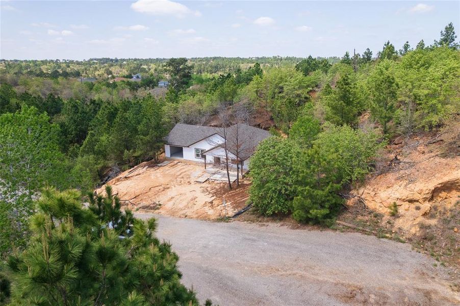 The property is situated in a wooded setting with various trees and natural landscaping