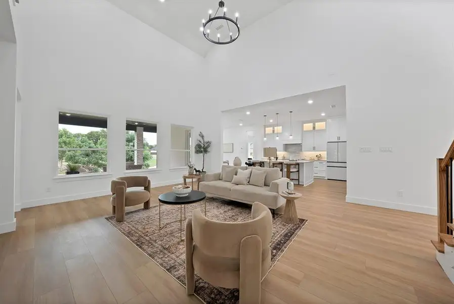 Two-story living area with high vaulted ceilings and a modern chandelier