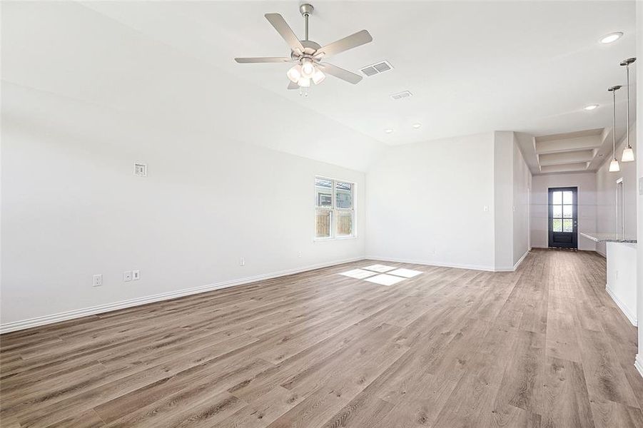 Unfurnished living room with light hardwood / wood-style floors, plenty of natural light, lofted ceiling, and ceiling fan