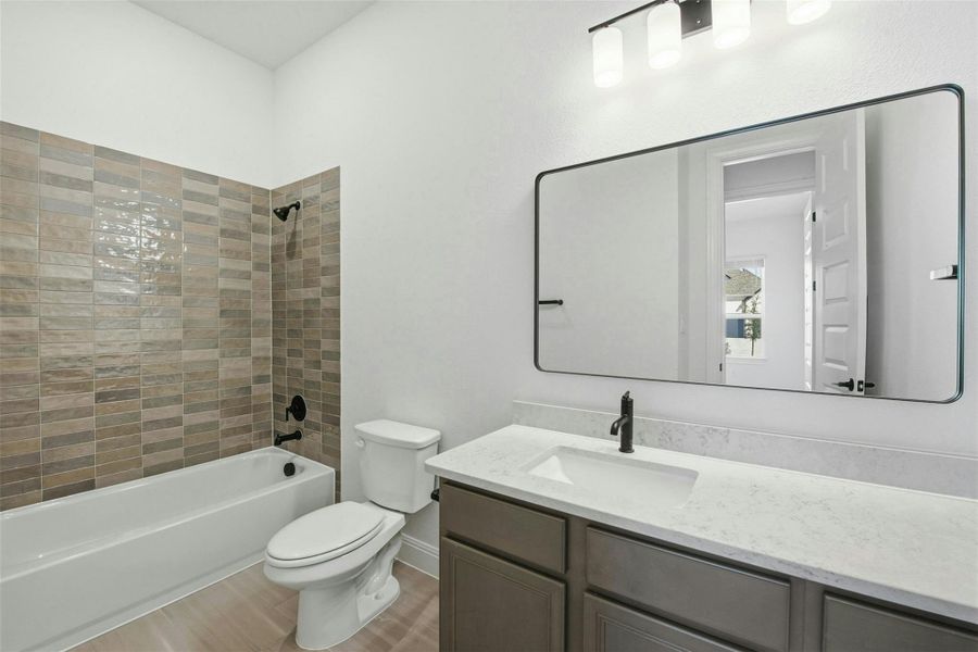 Bathroom with vanity, bathtub / shower combination, and light wood-style floors