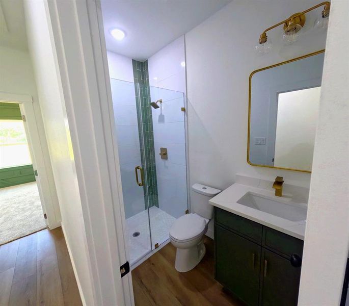 Full bathroom with vanity, dark wood-style floors, and a shower stall Full bathroom with vanity, dark wood-style floors, and a shower stall