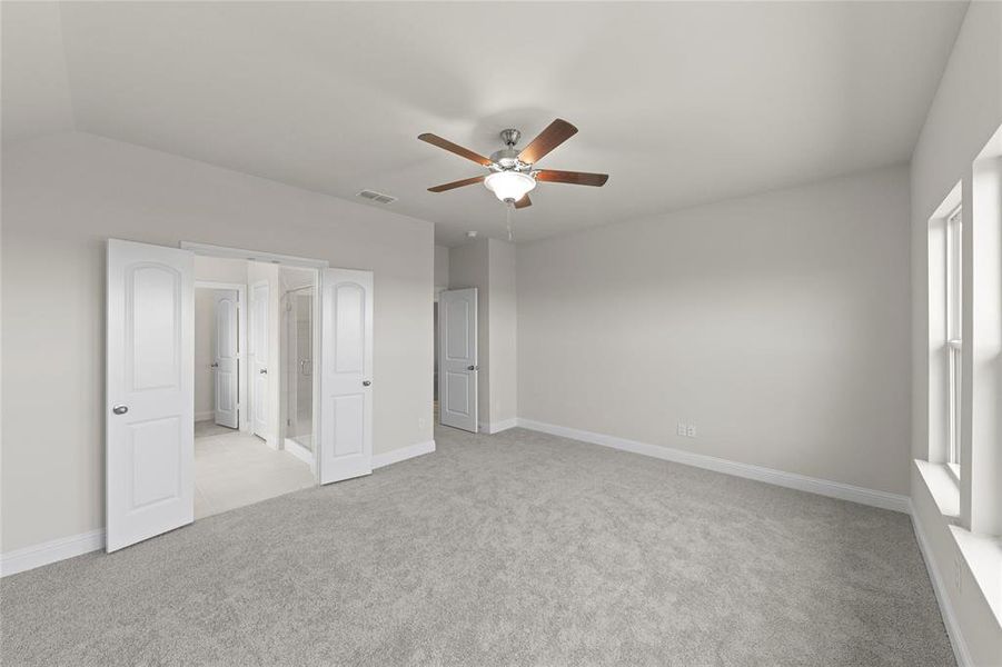 Carpeted spare room with ceiling fan and lofted ceiling