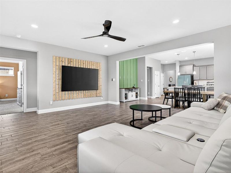 Open-concept living area featuring wood-finish flooring, recessed lighting, and a modern ceiling fan Open-concept living area featuring wood-finish flooring, recessed lighting, and a modern ceiling fan
