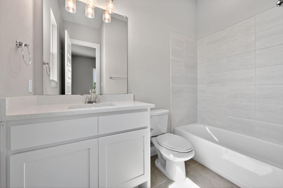 Full bath with vanity,  shower combination, and light tile patterned floors