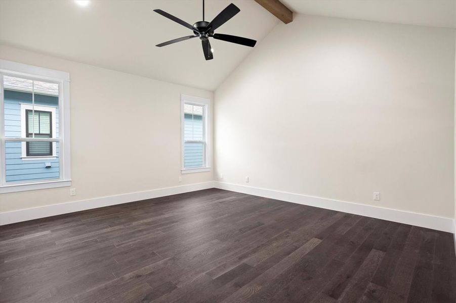 Unfurnished room with dark wood-type flooring, ceiling fan, and vaulted ceiling with beams