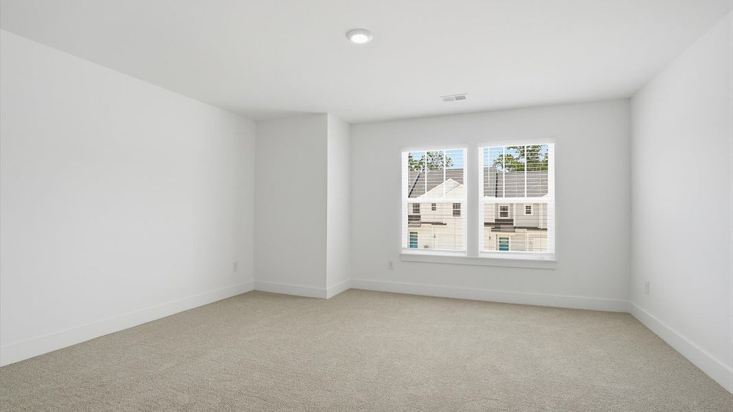 Elegant, carpeted bedroom with walk-in closet and large windows offering natural brightness Elegant, carpeted bedroom with walk-in closet and large windows offering natural brightness