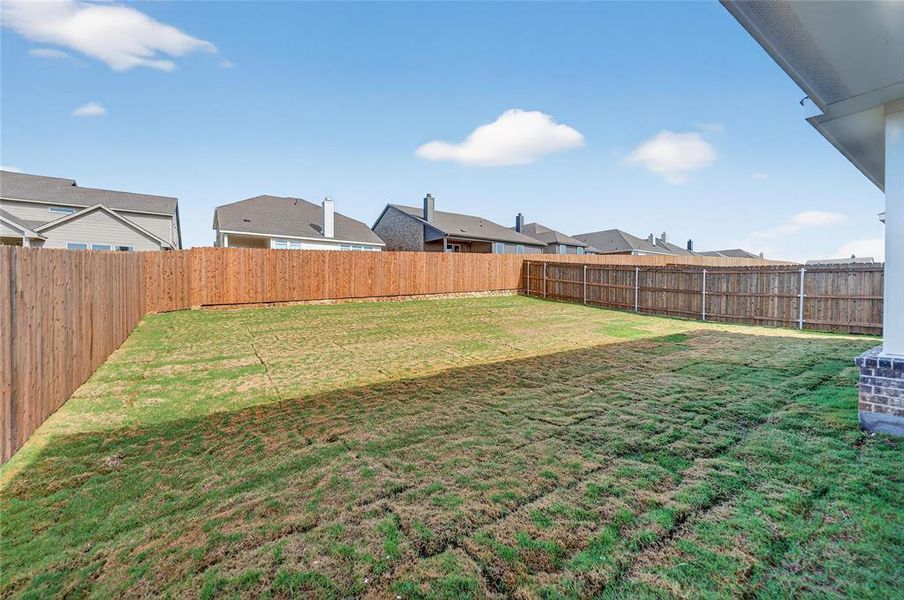Fenced backyard featuring a residential view