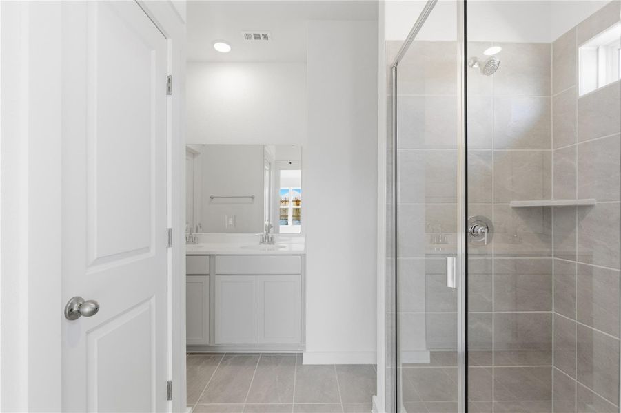 Full bathroom featuring vanity, a shower stall, and light tile patterned flooring