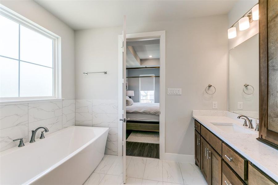 Bathroom with plenty of natural light, vanity, and a bath