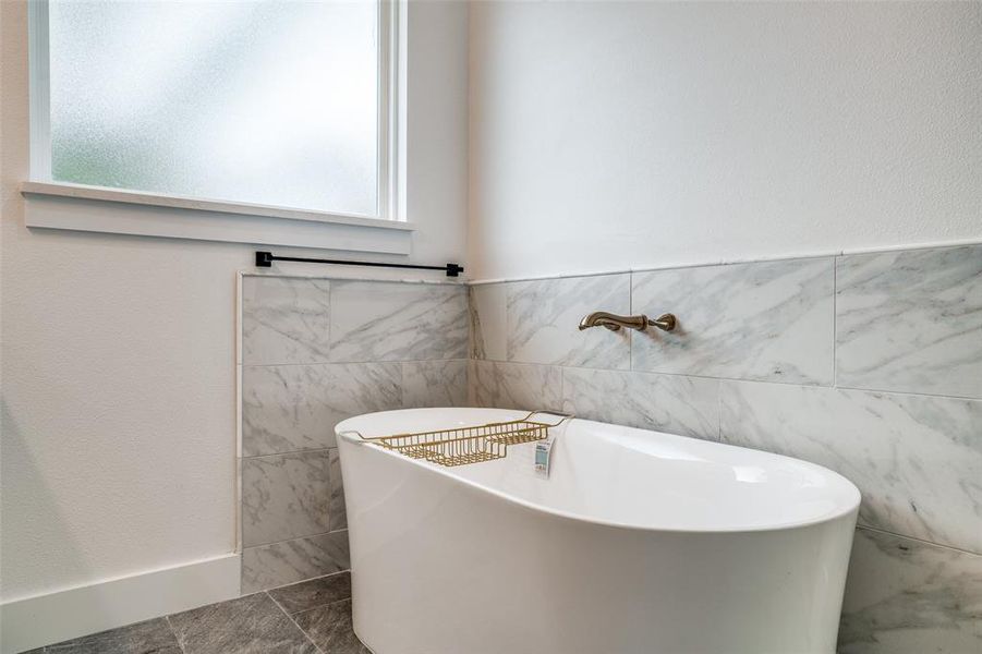 Bathroom with a bathtub and tile walls