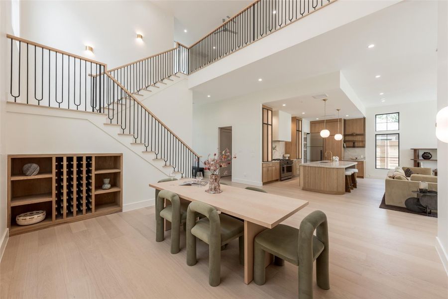 From the dining room, the home’s open architecture comes into full view, connecting the two story volume to the chef’s kitchen and great room while the custom whtie oak staircase adds a sculptural element of its own. From the dining room, the home’s open architecture comes into full view, connecting the two story volume to the chef’s kitchen and great room while the custom whtie oak staircase adds a sculptural element of its own.