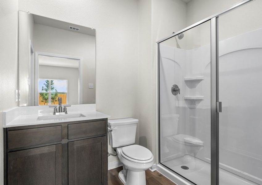 The master bathroom has a vanity and shower-tub combo.