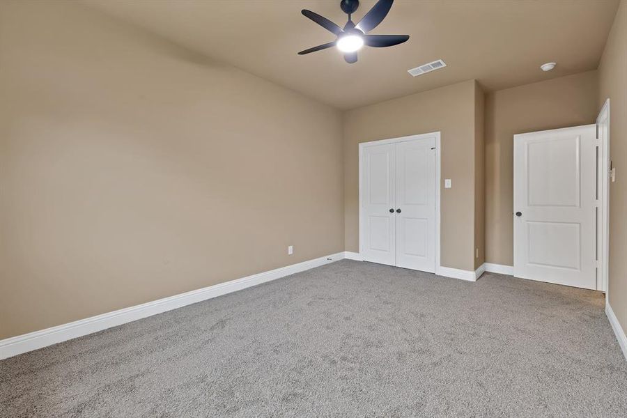 Unfurnished bedroom featuring visible vents, a closet, baseboards, carpet flooring, and ceiling fan Unfurnished bedroom featuring visible vents, a closet, baseboards, carpet flooring, and ceiling fan