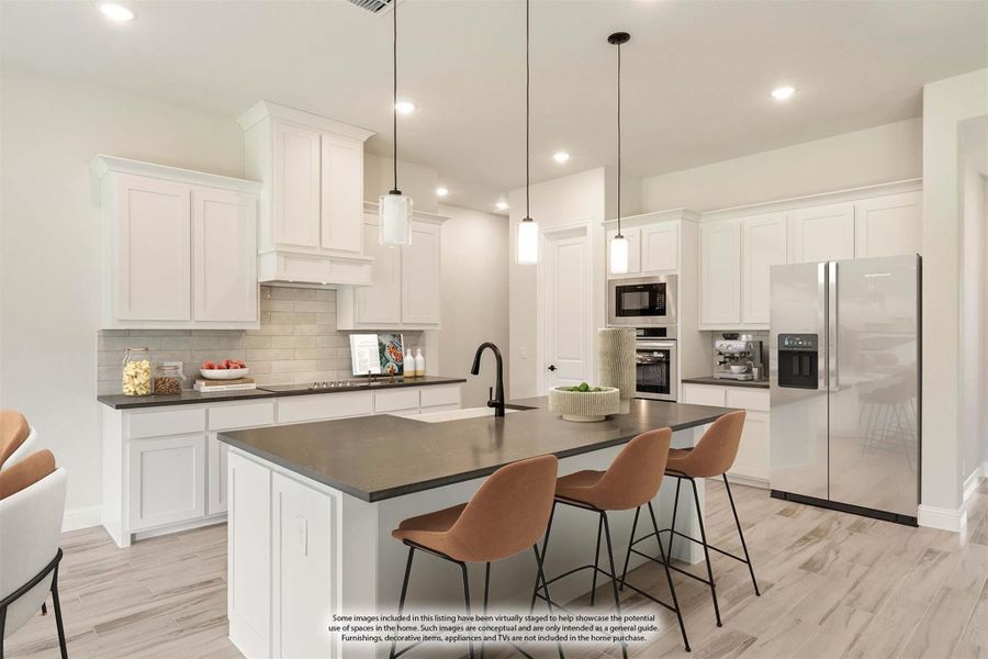Kitchen with white cabinets, dark countertop island, three bar stools, pendant lights, and stainless steel appliances