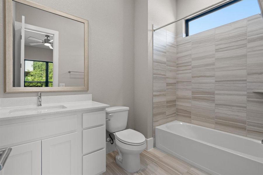 A well-appointed bathroom features a single vanity, modern tub, and elegantly tiled shower surround. A well-appointed bathroom features a single vanity, modern tub, and elegantly tiled shower surround.