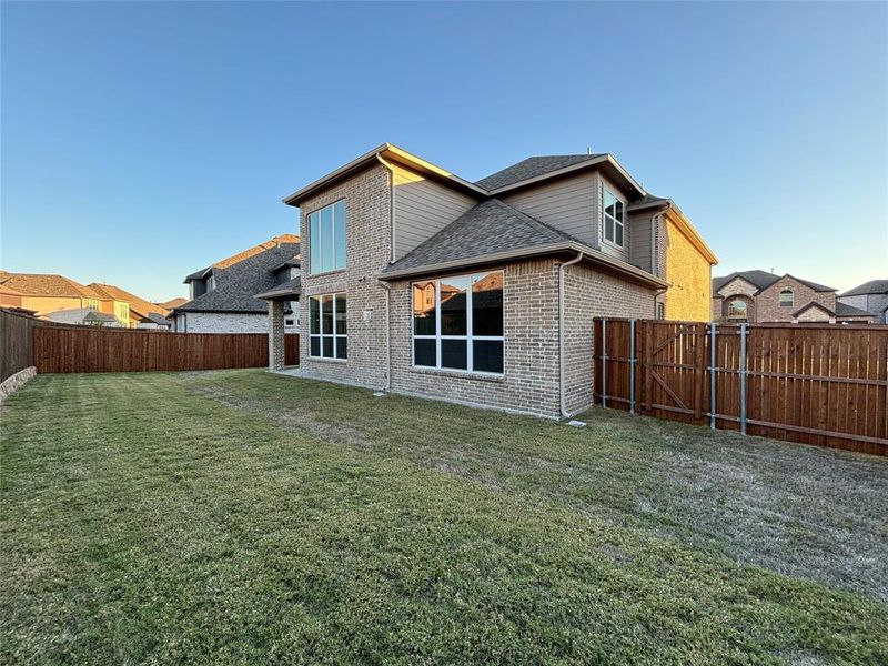 Rear view of property with a yard