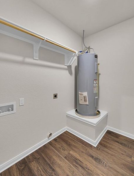 Laundry area featuring hookup for an electric dryer, electric water heater, dark wood finished floors, and hookup for a washing machine