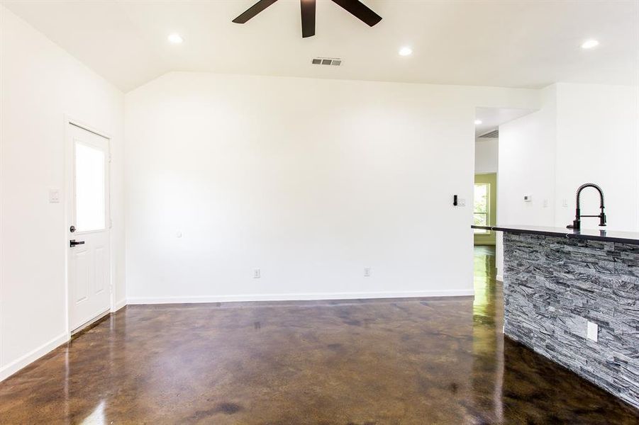 Living room featuring sink, lofted ceiling, and ceiling fan