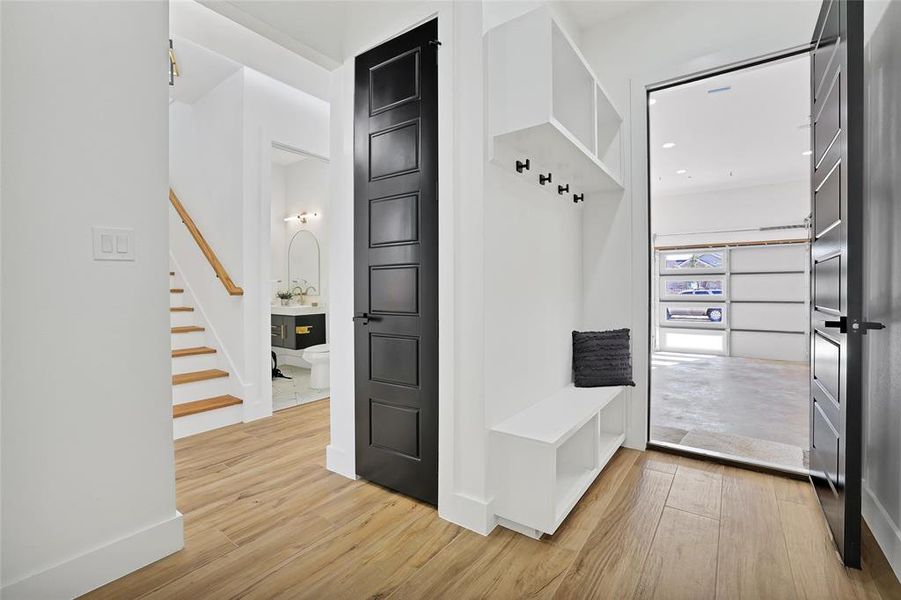 Mudroom with light wood finished floors and baseboards