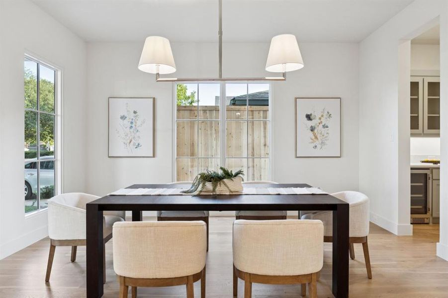 Dining space featuring light wood finished floors and wine cooler