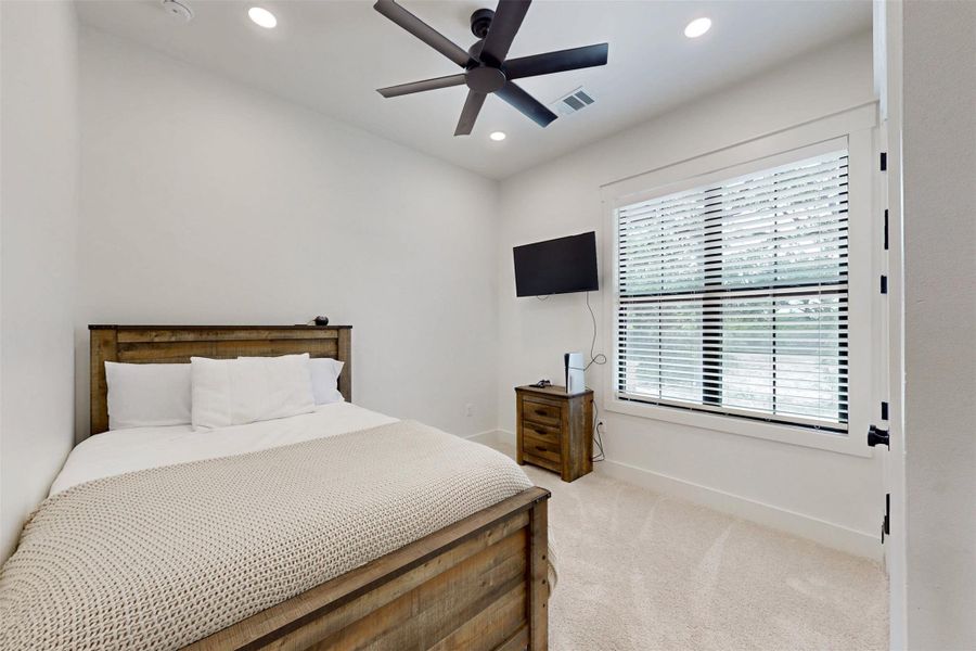 Bedroom featuring light carpet, recessed lighting, and a ceiling fan