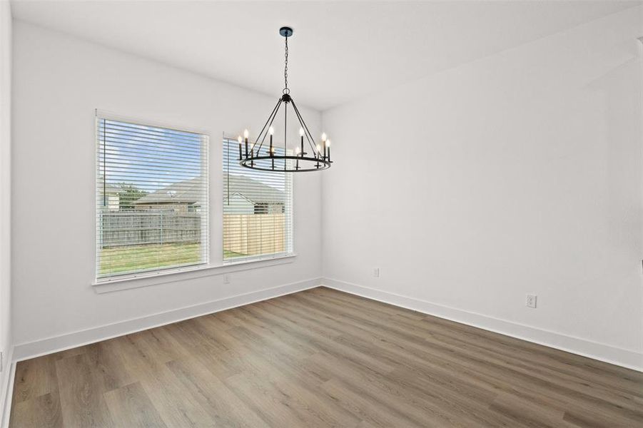 Unfurnished dining area featuring wood finished floors and hanging lights