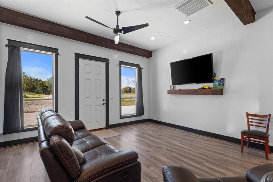 Living area featuring beam ceiling, wood finished floors, ceiling fan, and recessed lighting Living area featuring beam ceiling, wood finished floors, ceiling fan, and recessed lighting