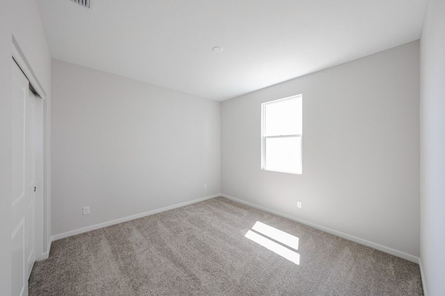 A room with a carpet and a door.