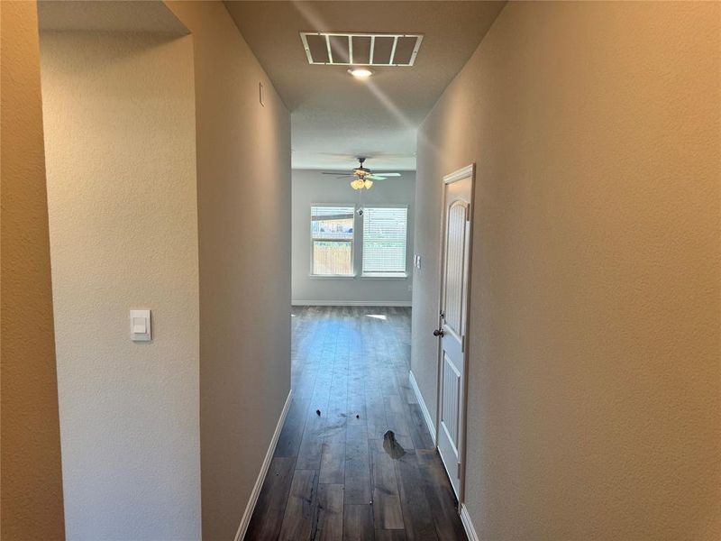 Hallway with dark wood finished floors and a textured wall Hallway with dark wood finished floors and a textured wall
