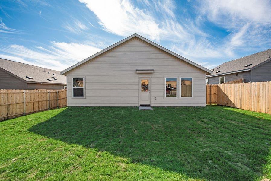 Back of property featuring a fenced backyard and a yard