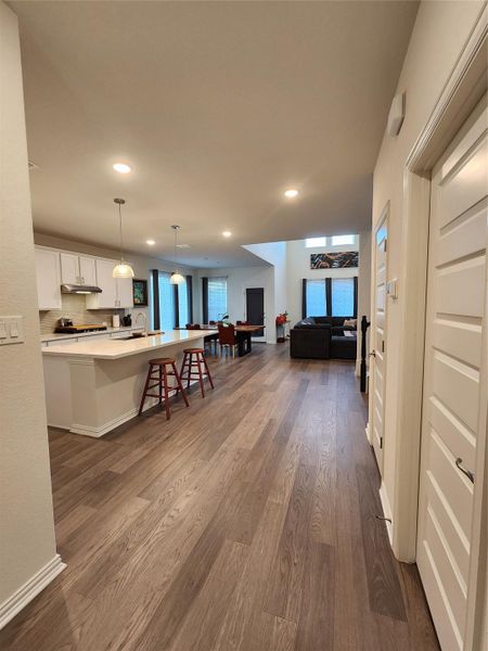 An open floorplan seamlessly connects the kitchen and living areas, highlighted by gleaming hardwood flooring.
