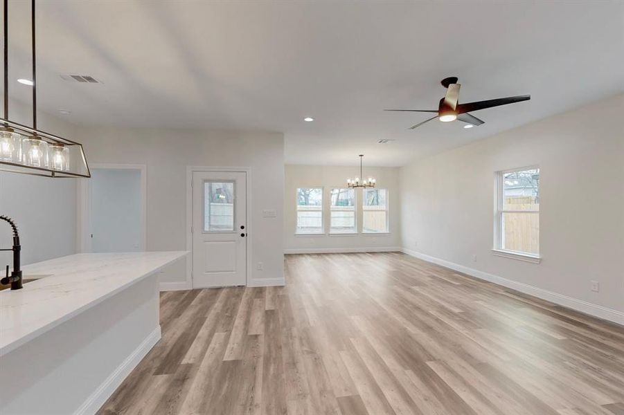 Entrance foyer featuring ceiling fan with notable chandelier and light hardwood / wood-style flooring