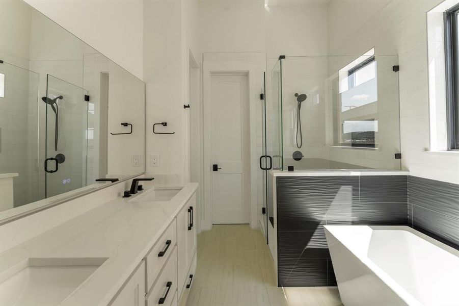 Full bathroom with a shower stall, double vanity, and a soaking tub