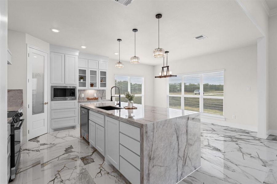 Polished stone floors and premium stone countertops define this elegant culinary space.