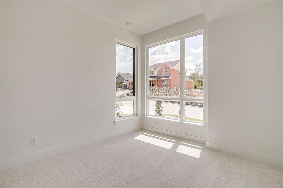 Carpeted spare room featuring a healthy amount of sunlight