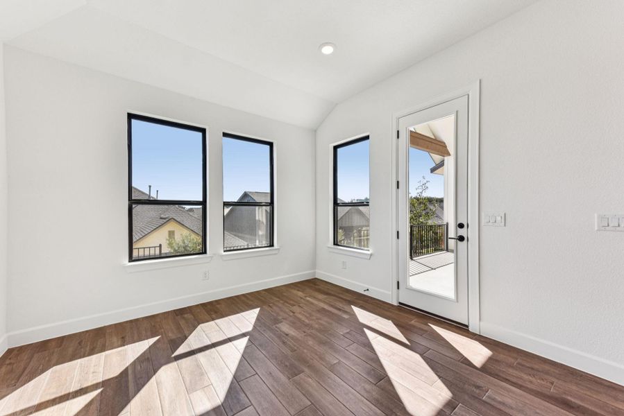 Empty room featuring dark wood finished floors, vaulted ceiling, and recessed lighting